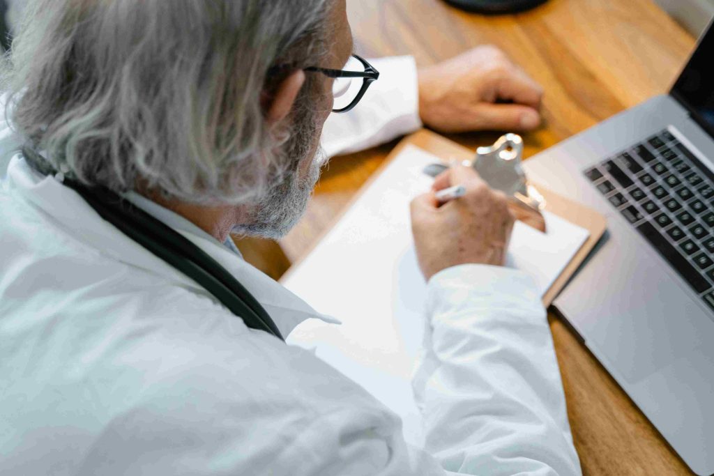 Oet Letter Correction: Regular Bundle With 10 Letters 1 regular - The best OET preparation course. doctor taking notes image.